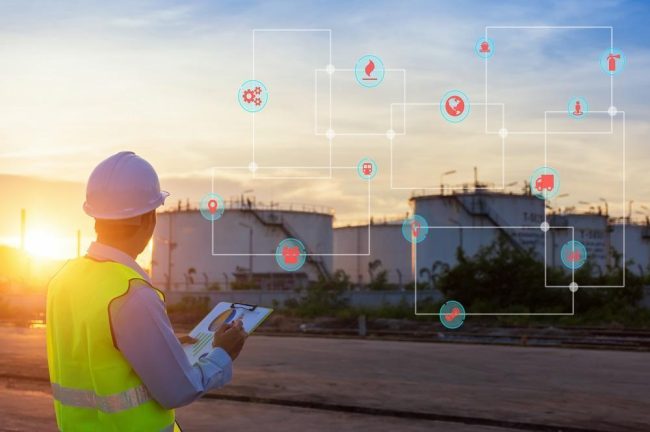 Engineer writing on the paper in front of the oil tank.Refinery, gas and oil